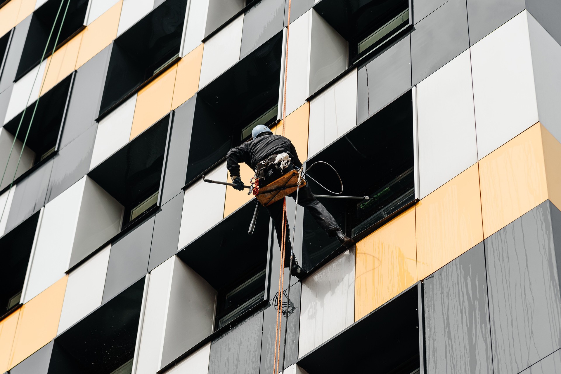 window cleaners wash windows on office building